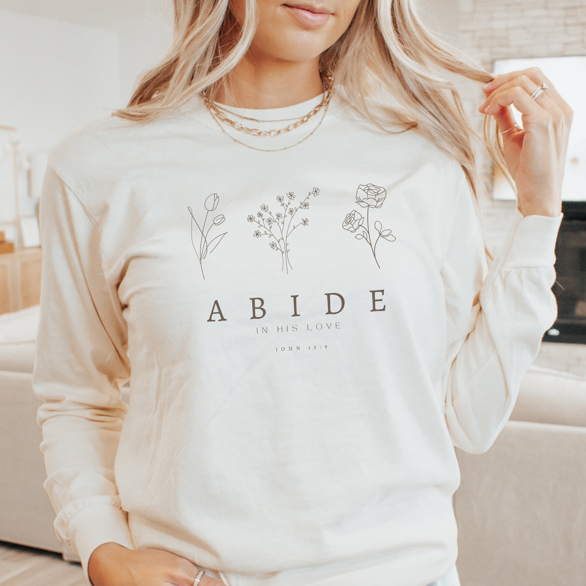 Person wearing a white sweatshirt with floral designs and text