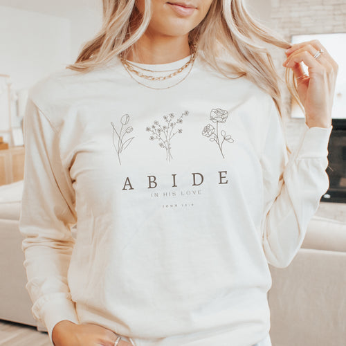 Person wearing a white sweatshirt with floral designs and text