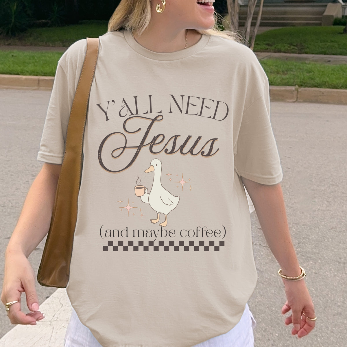Person wearing a t-shirt with 'Y'all Need Jesus (and maybe coffee)' text and a goose graphic.