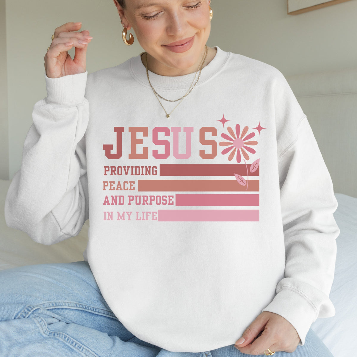Person wearing a white sweatshirt with a motivational quote in pink and red text.