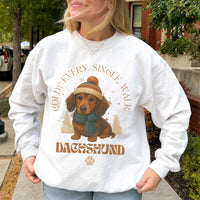 Person wearing a white sweatshirt with a dachshund graphic and text outdoors.
