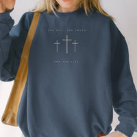Person wearing a navy blue sweatshirt with cross designs and text.