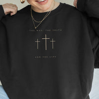 Black sweatshirt with cross design and text worn by a person