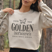 Person wearing a beige sweatshirt with 'Golden Retriever' text and design in a forest setting