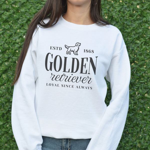 Person wearing a white sweatshirt with 'Golden Retriever' text and design on grass background
