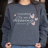 Person wearing a gray sweatshirt with 'Grandkids are a blessing' text and hearts design.