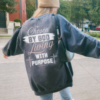 Person wearing a sweatshirt with a motivational message on the back, walking outdoors.
