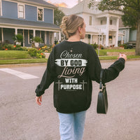 Woman wearing a black sweatshirt with motivational text, walking on a street.