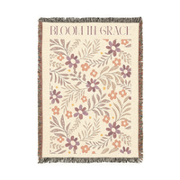 Floral patterned throw blanket with 'Bloom in Grace' text on a white background