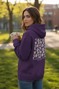Woman wearing a purple hoodie with floral design outdoors